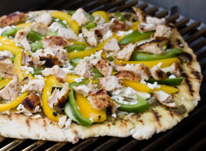 Leckere Pizza grillen Gegrillte Pizza mit Paprika und Hähnchenfleisch