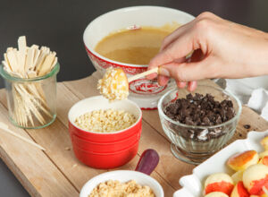 Apfelpops werden in Karamell getaucht