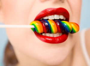 Eine Frau lutscht an einem Lolli Eine Frau lutscht an einem Lolli - Wie ungesund ist Zucker wirklich?