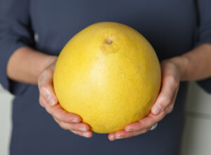 Frau hält eine Pomelo