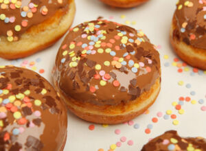 Berliner mit Schokoguss und bunten Streuseln