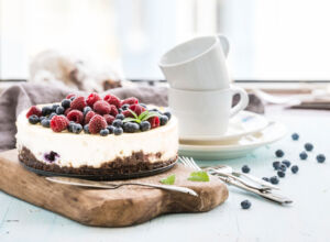 Oreo-Torte mit Früchten Käsekuchen auf Keksboden mit gefrorenen Waldfrüchten