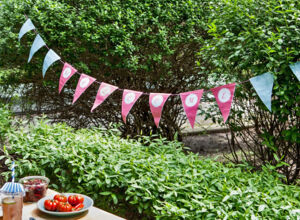Eine Wimpelkette hängt im Garten