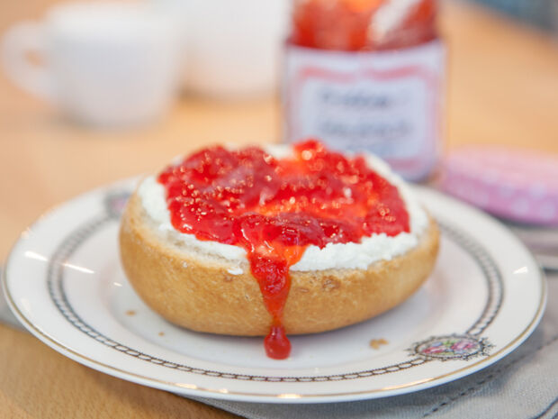 Erdbeermarmelade Ein mit Erdbeermarmelade bestrichenes halbes Brötchen