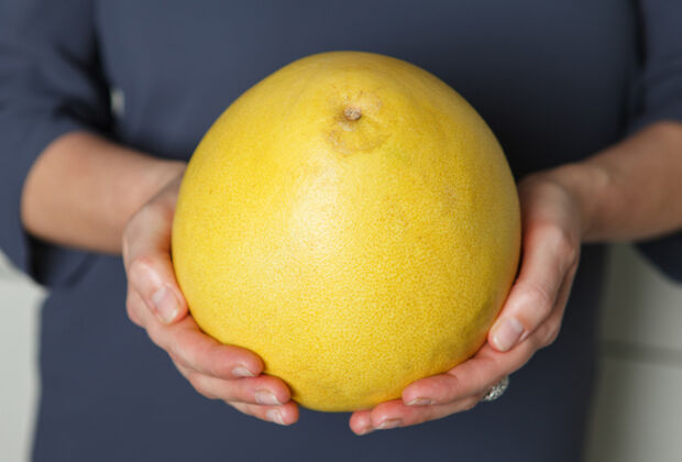 Pomelo Frau hält eine Pomelo